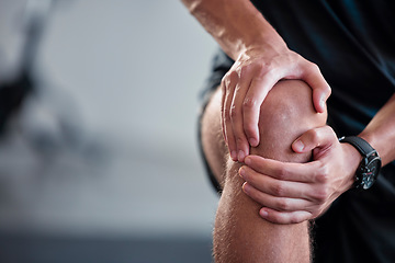 Image showing Hands, knee and pain with a sports man holding a joint injury while training in a gym for health. Fitness, accident and anatomy with a male athlete suffering from an injured body during exercise