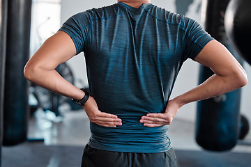 Image showing Hands, back pain and injury with a sports man holding a muscle while training in a gym for health. Fitness, accident and anatomy with a male athlete suffering from an injured body during exercise