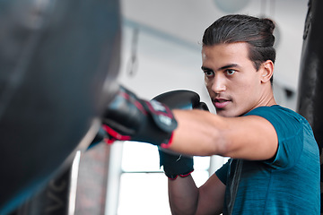 Image showing Fitness, serious man and boxing for exercise, workout or practice training at the gym for fight. Active and focused male boxer hitting punching bag with gloves for intense sports or fighting skill