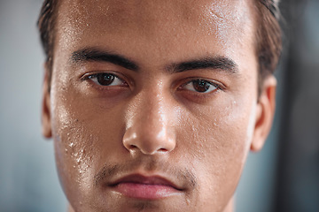 Image showing Portrait, sweat and intense with a sports man closeup in the gym for a cardio or endurance workout. Fitness, exercise and focus with a male athlete taking a break after health training for wellness