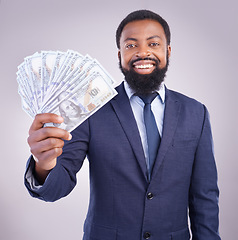 Image showing Portrait, money and investment with a business black man in studio on a gray background as a lottery winner. Cash, accounting and finance with a male employee holding dollar bills for the economy