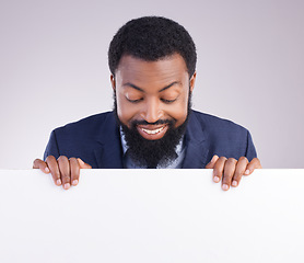 Image showing Mockup, happy and a black man looking at a board isolated on a white background in a studio. Smile, banner and an African businessman with a poste, reading space and showing a commercial message