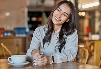 Image showing Thinking, happy and a woman waiting in a coffee shop, sitting at a table to relax over the weekend. Idea, cafe and smile with an attractive young female sitting in a restaurant feeling thoughtful