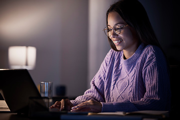 Image showing Woman, happy or laptop typing in night studying, education or homework research in living room on elearning website. Smile, student or technology in dark house for knowledge or university assignment