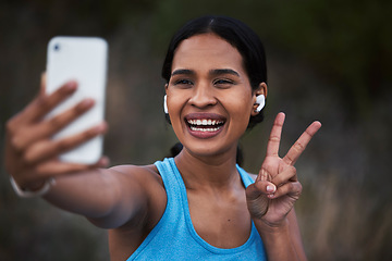 Image showing Selfie, peace and fitness with a sports woman outdoor, taking a picture during her cardio or endurance workout. Exercise, running and smile with a happy young female athlete posing for a photograph