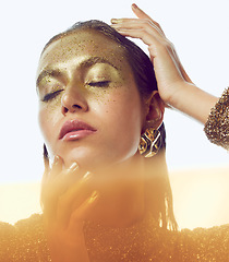 Image showing Gold, woman and luxury beauty sparkle of a female with makeup and cosmetic glitter. Creative fashion, cosmetics and yellow face glow of a young person with art shimmer and golden sparkles in a studio