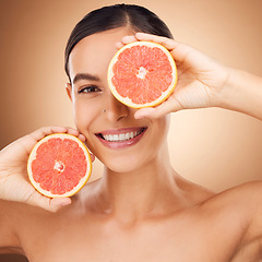 Image showing Beauty, health portrait and happy woman with grapefruit for fruit detox, healthcare or natural facial skincare routine. Vitamin c food product, studio face and female nutritionist on brown background
