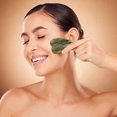 Image showing Skincare, gua sha stone and woman face cleaning of a young person with happiness in a studio. Happy smile and dermatology treatment of a female with cosmetics, spa and cosmetology luxury facial