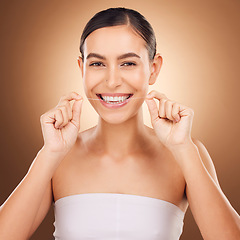 Image showing Dental, floss and happy woman cleaning teeth for oral hygiene routine, self care flossing or tooth healthcare. Mouth plaque treatment, face portrait smile and studio female beauty on brown background