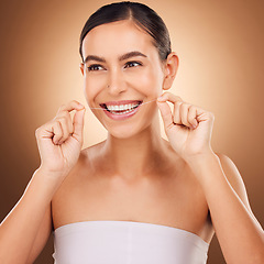 Image showing Dental floss, face and happy woman cleaning teeth for oral hygiene routine, self care flossing or tooth healthcare. Mouth plaque treatment, gum care smile and studio female beauty on brown background