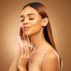 Image showing Woman with hand on face, hair and skincare with bronze glow and luxury salon treatment on brown background. Beauty, makeup and skin care cosmetics, hispanic model with straight hairstyle in studio.