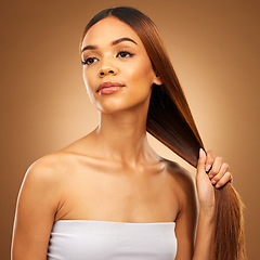 Image showing Haircare, woman with strong straight hair in hand and studio space with texture and salon shine. Beauty model, healthy hairstyle and wellness, natural keratin product promotion on brown background.