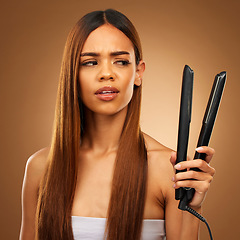 Image showing Hair, flat iron and confused woman in studio for beauty, wellness and keratin treatment on brown background. Hairdresser mockup, salon and girl with doubt for heat, haircare texture and cosmetics