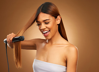 Image showing Hair, flat iron and woman with smile in studio for beauty, wellness and keratin treatment on brown background. Hairdresser mockup, salon and girl hairstyle for heat, haircare texture and cosmetics