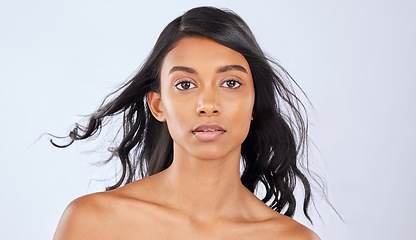 Image showing Girl, hair or wind in studio portrait for growth, healthy natural shine or grooming wellness on white background. Face of glowing young Indian woman, salon spa mockup or luxury self care cosmetics