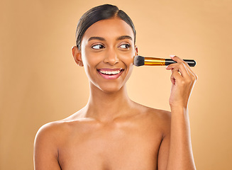 Image showing Indian woman, beauty and brush for makeup with smile, cosmetic tools, skin glow and face on studio background. Happy female, thinking and cosmetology, apply foundation or powder with self care