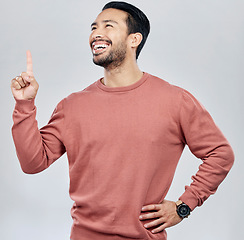 Image showing Happy, smile and pointing with man in studio for idea, product placement and announcement. Success, confident and direction with male isolated on white background for positive, advertisement or pride