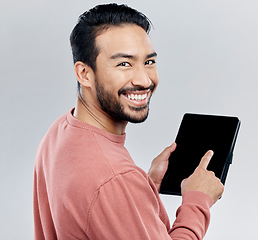 Image showing Portrait, smile and Asian man with tablet in studio isolated on a gray background. Face, technology and happy male model with digital touch screen for social media, web scrolling or internet browsing