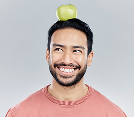 Image showing Happy, healthy and an Asian man thinking of an apple isolated on a white background in a studio. Smile, idea and a Chinese guy with a fruit for nutrition, diet and organic wellness on a backdrop