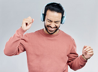 Image showing Fun, dance and Asian man with headphones, streaming music and happiness against a grey studio background. Japan, male and guy with headset, listening radio and sounds with movement, silly and smile