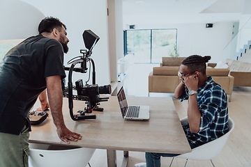 Image showing A cameraman talking with a African American man as they preparing to shoot a commercial video