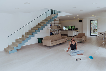 Image showing Training At Home. Sporty man doing training while watching online tutorial on laptop, exercising in living room, free space