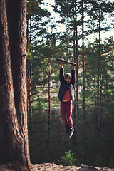 Image showing Teen boy at bungee in autumn forest