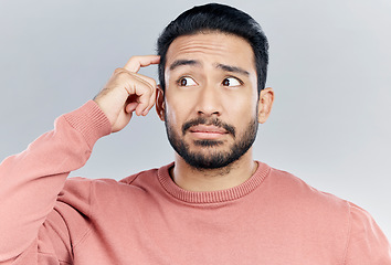 Image showing Thinking, question and doubt with a man in studio on a gray background looking thoughtful or contemplative. Confused, idea and memory with a young asian male trying to remember but feeling unsure