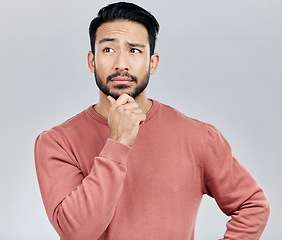 Image showing Confused, thinking and Asian man with ideas, decision and thoughtful against grey studio background. Japan, male and guy with wonder, opportunity and confused with thoughts, contemplation and future