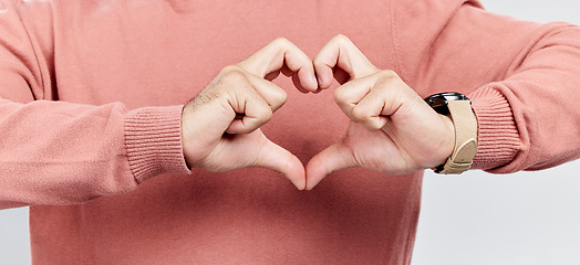 Image showing Man, heart and hands for love in studio to show support, thank you or charity sign language. Male model person with hand icon for kindness, care and hope review, motivation or emoji opinion feedback