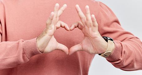 Image showing Hands, heart and man with love in studio to show support, thank you or charity sign language. Male model person with hand icon for kindness, care and hope review, motivation or emoji opinion feedback