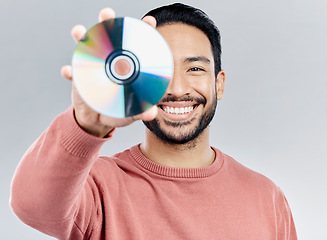 Image showing Man, holding and compact disc in studio portrait for smile, happiness and technology by white background. Asian model, student and cd in hand for movie, audio and sound with happy, excited and tech