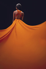 Image showing Dress, train and woman back, elegant style and beauty on dark background, fashion and model in orange in studio. Classy female, glamour and stylish ballgown with sexy person, luxury and designer wear