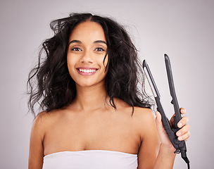 Image showing Portrait, happy woman and hair straightener for beauty in studio, transformation or smile on background. Female model, haircare and heat styling equipment of ironing curly hairstyle, texture or tools