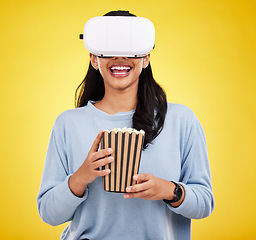 Image showing Woman is eating popcorn, happy and VR goggles, snack for watching tv or movie on yellow studio background. Future technology, virtual reality experience and corn treat, cinema and UX with metaverse