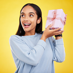 Image showing Happy woman, excited and gift box in a studio with a smile from surprise present for birthday. Giveaway prize, isolated and yellow background of a young female student feeling positive and cheerful