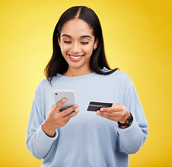 Image showing Woman with smartphone, credit card and ecommerce with smile and online shopping on yellow studio background. Fintech, online payment and bank app with happy female, checkout and internet banking