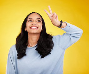 Image showing Happy, woman and thinking of peace fingers in studio, background and color backdrop. Female model, v sign and smile with hands for victory, fun mood and happiness of gen z, vote and freedom of emoji