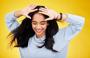 Image showing Happy, freedom and calm with a woman on a yellow background in studio feeling carefree or cheerful. Smile, relax and relief with an attractive young female posing eyes closed in a peaceful mood