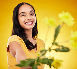 Image showing Happy, summer and portrait of woman with flowers or plants feeling excited and isolated in a studio yellow background. Smile, happiness and young female holding a gift with a floral blossom aesthetic