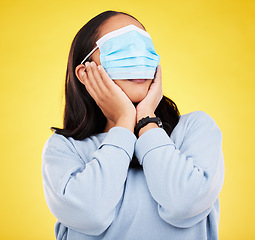 Image showing Covid, face mask and shock with woman and blindfold in studio for medical, crazy and healthcare. Comic, virus and carefree with female on yellow background for vaccine, protection and pandemic