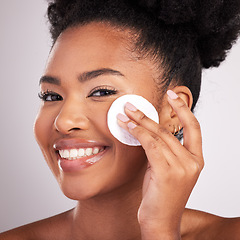 Image showing Black woman, cotton and skincare in studio with smile in headshot, cleaning or makeup removal by background. Young model, wipe and clean for natural glow, wellness and cosmetic beauty for self care