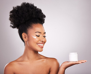 Image showing Black woman, moisturizer cream and smile for skincare beauty or cosmetics against a gray studio background. Happy African female smiling and holding moisturizing creme, lotion or facial product