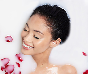 Image showing Beauty, milk and rose petals with woman in bath for spa treatment, relax and skincare. Wellness, cosmetics and pampering with female and flowers from top view for grooming, satisfaction and self care