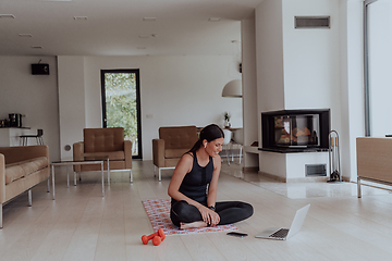 Image showing Young Beautiful Female Woman with Trainer via Video Call Conference in Bright Sunny House. Healthy Lifestyle, Wellbeing and Mindfulness Concept.