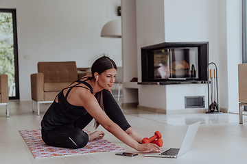 Image showing Young Beautiful Female Woman with Trainer via Video Call Conference in Bright Sunny House. Healthy Lifestyle, Wellbeing and Mindfulness Concept.