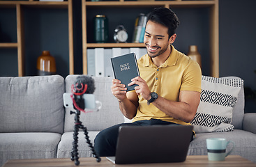 Image showing Bible, smile and man study with phone and microphone online live streaming. Asian male on home sofa with Christian religion book as blog or podcast content creator or influencer teaching or studying