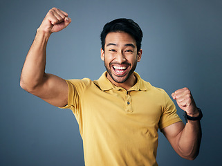 Image showing Indian man, celebrate and fist in studio portrait for winning mindset, happiness or achievement by background. Young model, male student or celebration with happy, excited face or winning for success