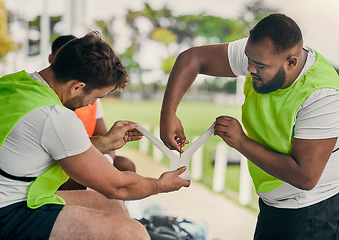 Image showing Men, cutting bandage or rugby team on fitness break, exercise workout or training in a sports game. Preparation, friends or group of people in practice match with tape, strap or wrap on stadium bench