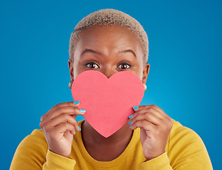 Image showing Paper, heart and shy with black woman in studio for love, date and kindness. Invitation, romance and feelings with female and shape isolated on blue background for emotion, support and affectionate